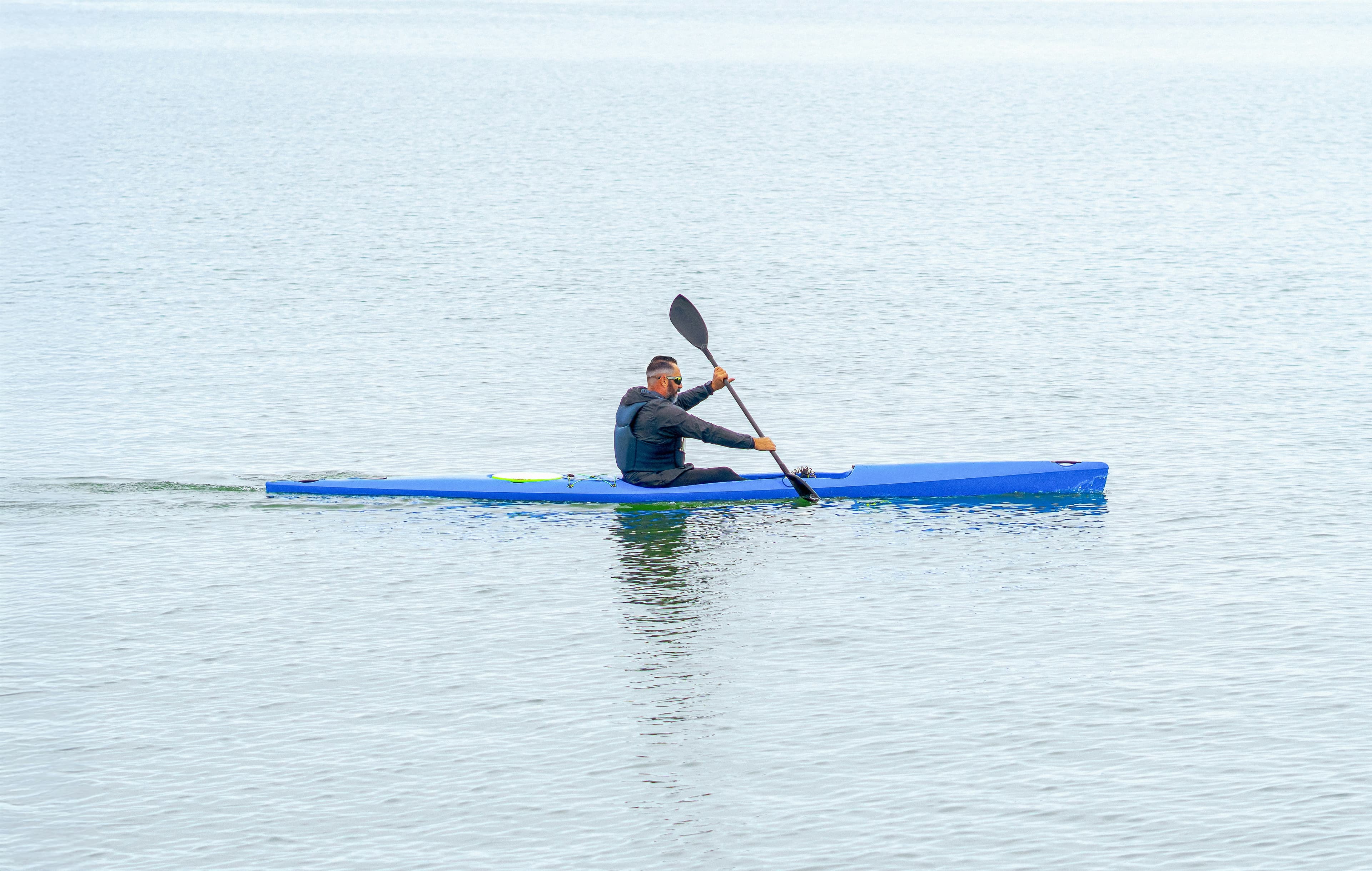 A kayaker paddling across calm water