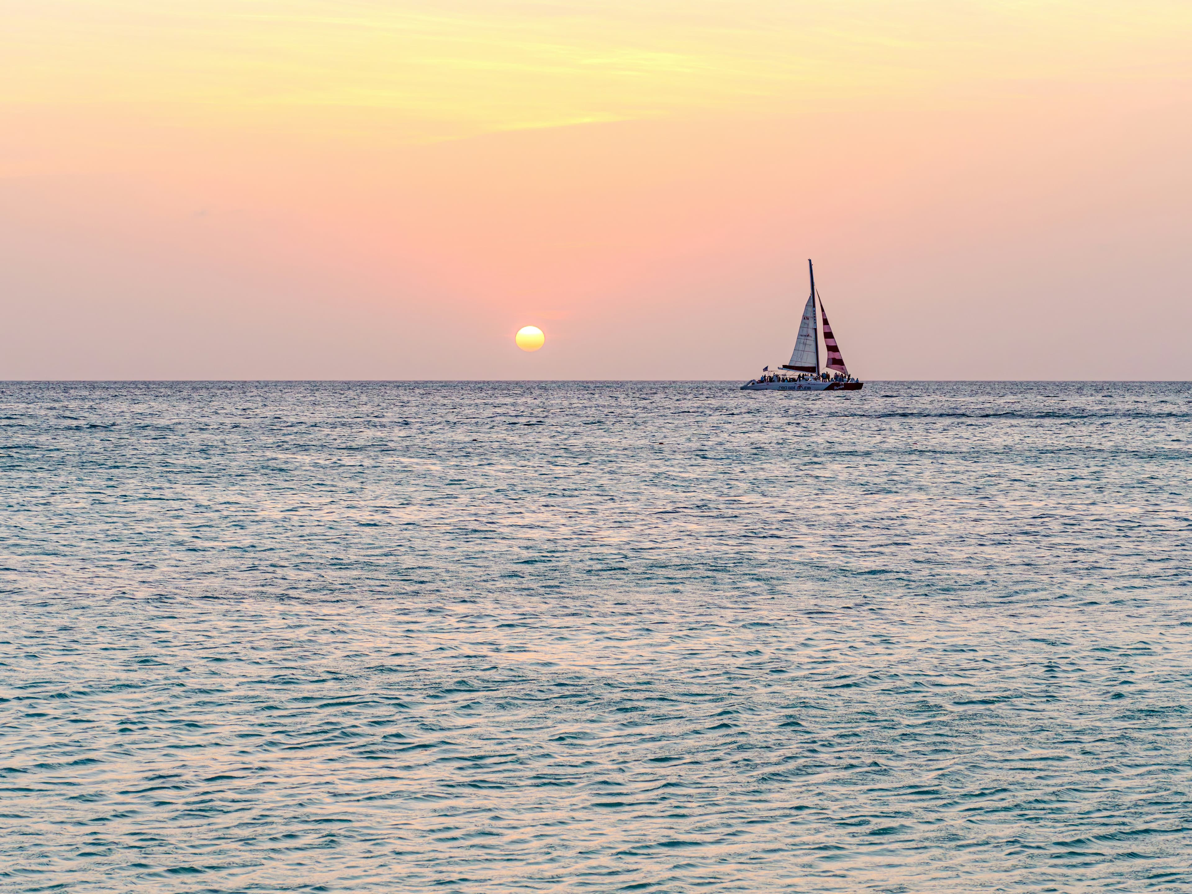 A sailboat on the ocean at sunset